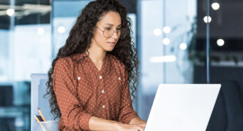 A woman BID manager working in front of her laptop