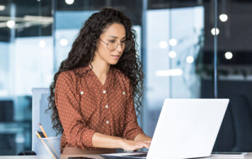 A woman BID manager working in front of her laptop