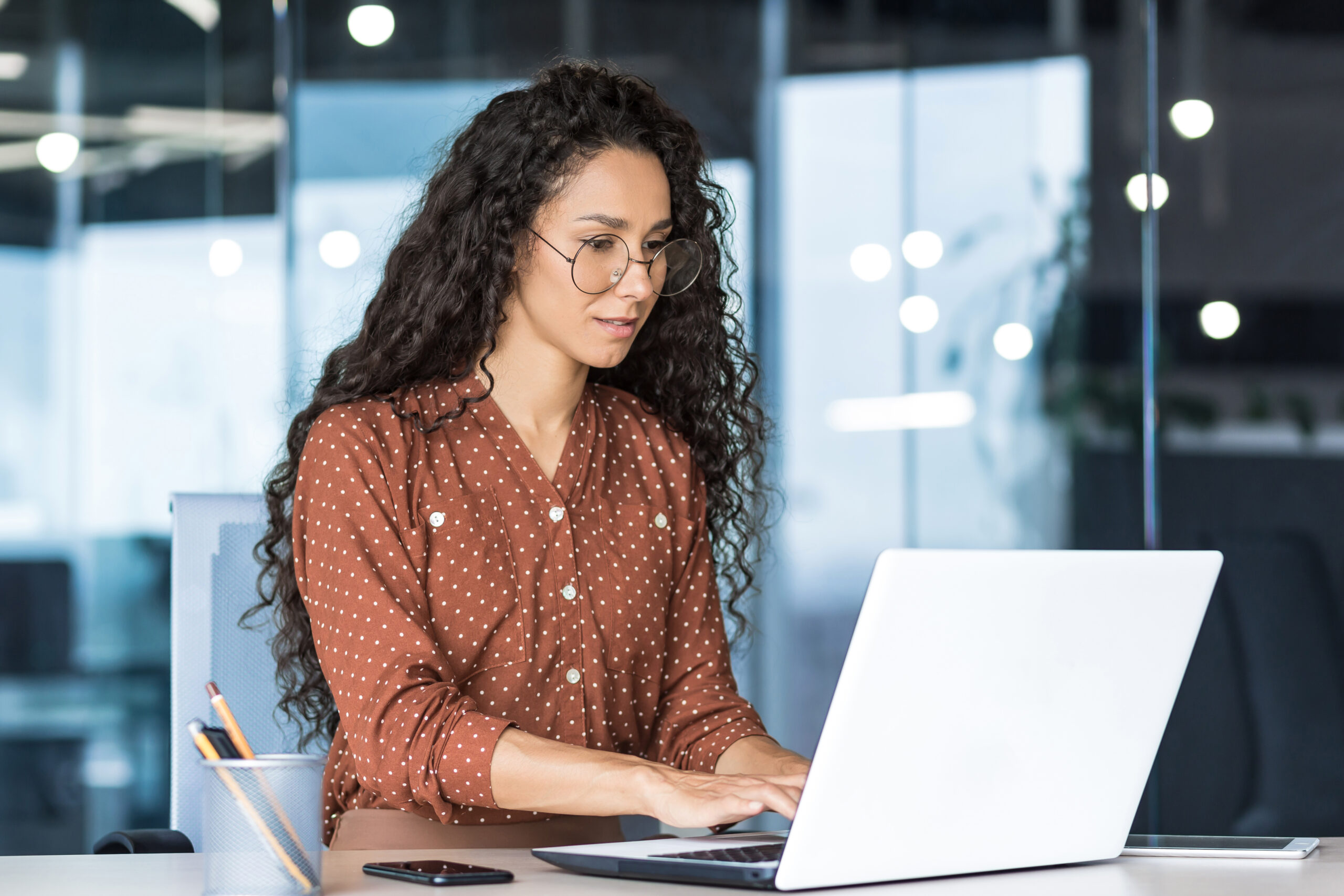 A woman BID manager working in front of her laptop